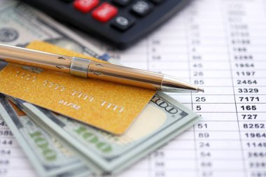 Kredi kartı ve tükenmez kalemle Amerikan Doları 'na ait para banknotları hesaplama belgelerinde. Amerika Birleşik Devletleri 'nde iş, mali işlemler ve muhasebe
