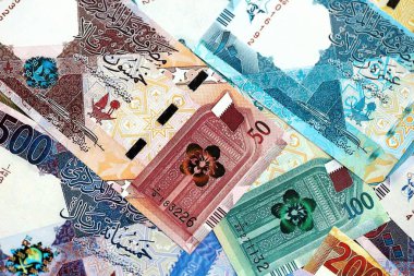 Katarlı riyal para banknotları masanın üzerinde büyük bir yığın halinde duruyor. Katar 'da finans ve iş kavramı