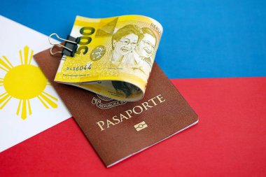 Filipinler pezosu para ve pasaport banknotları bayrağın üzerinde. Seyahat ve tatil kavramı