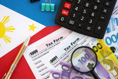 Filipinler pezosu para faturaları ve vergi formlu hesap makinesi. Vergi ve muhasebe kavramı