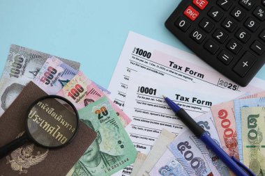 Tayland baht para faturaları ve mavi üzerine yakın vergi formlu hesap makinesi. Vergi ve muhasebe kavramı