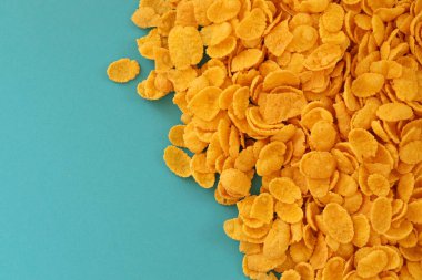 Kahvaltı gevreklerinin arka planında büyük miktarda mavi arka planda yakın plan, üst manzara.