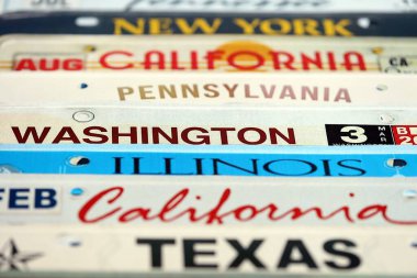 Çeşitli eyalet isimleriyle eski bir Amerikan araba plakası. Amerika 'da araba kullanma kavramı. Araç ruhsatına ulaşılıyor.