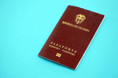 Açık mavi masa üzerinde Kolombiya Cumhuriyeti kırmızı pasaportu yakın plan. Seyahat ve turizm kavramı