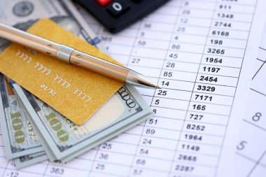 Kredi kartı ve tükenmez kalemle Amerikan Doları 'na ait para banknotları hesaplama belgelerinde. Amerika Birleşik Devletleri 'nde iş, mali işlemler ve muhasebe
