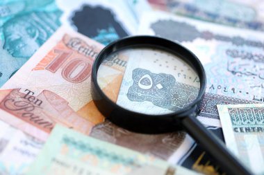 Mısır para birimi banknotları ve büyüteç yakın çekim. Finansal izleme ve vergilendirme kavramı