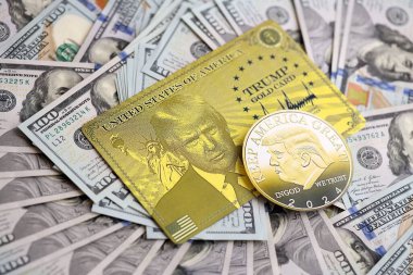 KYIV, UKRAINE - 13 Aralık 2025 Trump altın kartı ve hatıra parası büyük miktardaki 100 dolarlık banknotlar