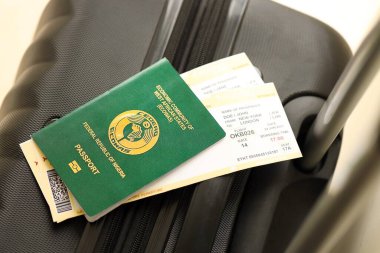 Nijerya pasaportu ve seyahat çantasındaki uçak biletleri yakın plan. Seyahat ve tatil kavramı