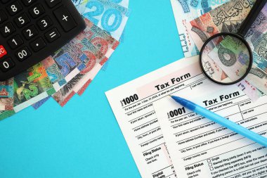 Kuveyt dinarı para faturaları ve mavi üzerine yakın vergi formlu hesap makinesi. Vergi ve muhasebe kavramı