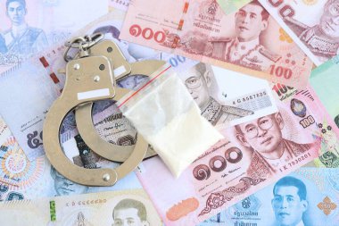Tayland baht para birimi faturaları ve kelepçeli kokain paketi. Uyuşturucu suçları kavramı