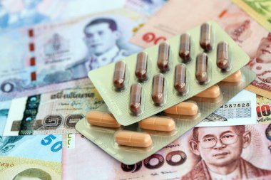 Tayland baht para birimi faturaları ve ilaç hapları. İlaç ve eczane kavramı