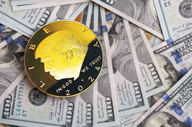 KYIV, UKRAINE - 13 Aralık 2025 Büyük miktardaki 100 dolarlık banknotlar üzerinde Trump altın madeni para