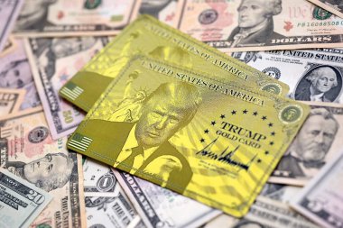 KYIV, UKRAINE - 13 ARALIK 2025 Trump altın kart hatırası büyük miktarda Amerikan doları banknotları yakın çekim