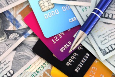 100 dolarlık banknotlar ve kredi kartlı gümüş kalemler. ABD 'de iş hesaplama ve muhasebe kavramı