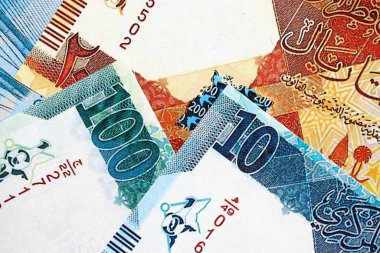 Katarlı riyal para banknotları masanın üzerinde büyük bir yığın halinde duruyor. Katar 'da finans ve iş kavramı