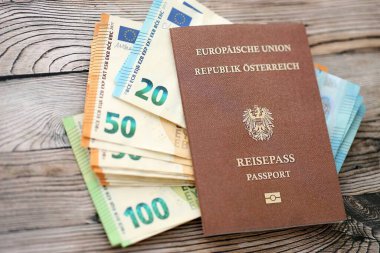 Avusturya pasaportu, tahtadan arka planda Avro para banknotlarıyla birlikte yakın planda bulunuyor. Avrupa konseptinde nakit ve ödemeler