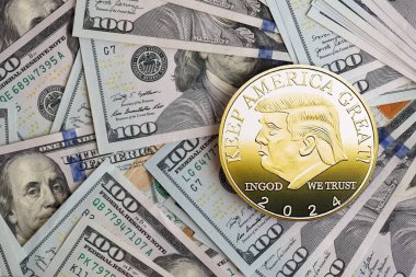 KYIV, UKRAINE - 13 Aralık 2025 Büyük miktardaki 100 dolarlık banknotlar üzerinde Trump altın madeni para