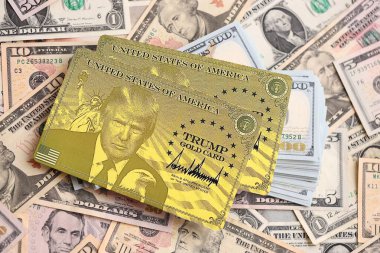KYIV, UKRAINE - 13 ARALIK 2025 Trump altın kart hatırası büyük miktarda Amerikan doları banknotları yakın çekim