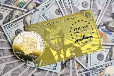 KYIV, UKRAINE - 13 Aralık 2025 Trump altın kartı ve hatıra parası büyük miktardaki 100 dolarlık banknotlar