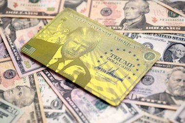 KYIV, UKRAINE - 13 ARALIK 2025 Trump altın kart hatırası büyük miktarda Amerikan doları banknotları yakın çekim