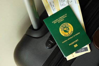Nijerya pasaportu ve seyahat çantasındaki uçak biletleri yakın plan. Seyahat ve tatil kavramı