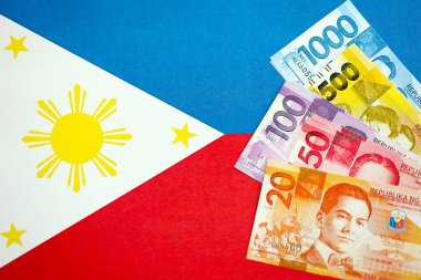 Filipinler Peso para birimi banknotları bayrağın üzerinde duruyor. İş ve yatırım kavramı