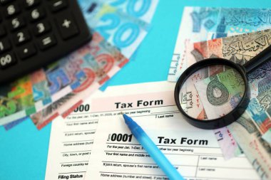 Kuveyt dinarı para faturaları ve mavi üzerine yakın vergi formlu hesap makinesi. Vergi ve muhasebe kavramı