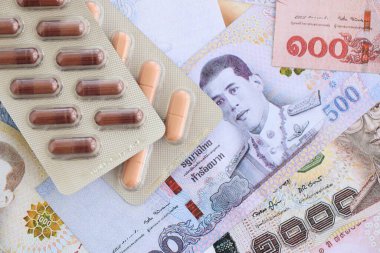 Tayland baht para birimi faturaları ve ilaç hapları. İlaç ve eczane kavramı