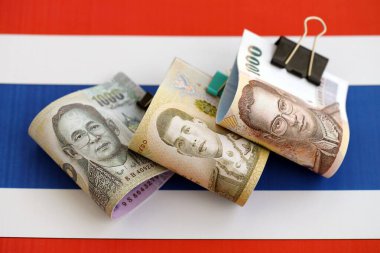 Tayland baht para birimi faturaları bayrağın üzerinde duruyor. İş ve yatırım kavramı