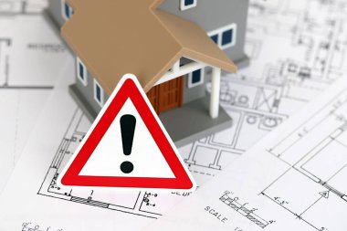 KYIV, UKRAINE - 3 Ekim 2025 Ünlem işareti ve beyaz planlı oyuncak ev inşaatı için yakın plan