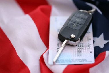 Uzaktan kumandalı ateşleme anahtarları ve ABD bayrağında ehliyet kartı. Amerika 'da araba kullanma kavramı. Araç sahipliği