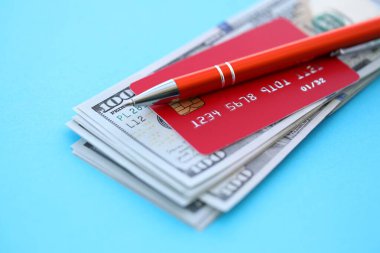Kredi kartı ve tükenmez kalemle Amerikan doları para banknotları açık mavi arka planda. Amerika Birleşik Devletleri 'nde iş, mali işlemler ve muhasebe