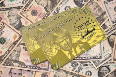 KYIV, UKRAINE - 13 ARALIK 2025 Trump altın kart hatırası büyük miktarda Amerikan doları banknotları yakın çekim