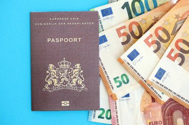 Hollanda pasaportu, mavi arka planda Avro para banknotlarıyla birlikte yakın planda bulunuyor. Avrupa 'da maaş ve emeklilik kavramı
