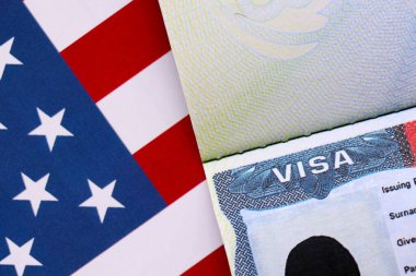 Birleşik Devletler bayrağı ve Birleşik Devletler vizesi. Göçmenlik ve Amerika Birleşik Devletleri 'ne seyahat kavramı. Amerikan bayrağının arka planındaki pasaportta vize var.