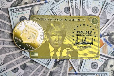 KYIV, UKRAINE - 13 Aralık 2025 Trump altın kartı ve hatıra parası büyük miktardaki 100 dolarlık banknotlar