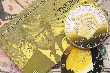 KYIV, UKRAINE - 13 Aralık 2025 Trump altın kartı ve hatıra parası büyük miktarda Amerikan doları banknotları yakın plan