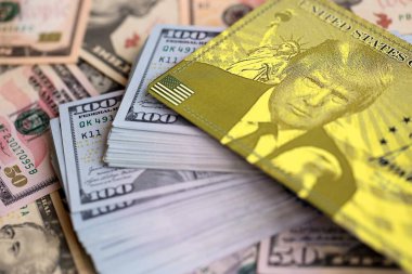 KYIV, UKRAINE - 13 ARALIK 2025 Trump altın kart hatırası büyük miktarda Amerikan doları banknotları yakın çekim