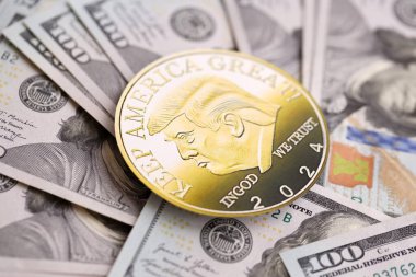 KYIV, UKRAINE - 13 Aralık 2025 Büyük miktardaki 100 dolarlık banknotlar üzerinde Trump altın madeni para