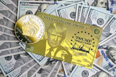 KYIV, UKRAINE - 13 Aralık 2025 Trump altın kartı ve hatıra parası büyük miktardaki 100 dolarlık banknotlar