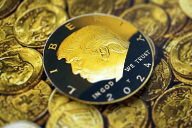 KYIV, UKRAINE - 13 ARALIK 2025 Parlak altın madeni paralar üzerine Trump madeni para