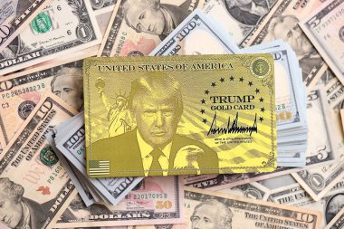 KYIV, UKRAINE - 13 ARALIK 2025 Trump altın kart hatırası büyük miktarda Amerikan doları banknotları yakın çekim