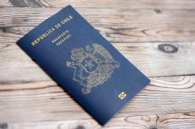 Şili Cumhuriyeti pasaportu ahşap masaya yakın duruyor. Şili mavisi yeni pasaport defteri detaylarıyla