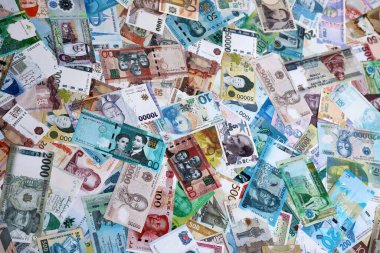 Dünyanın çeşitli para birimlerinden farklı renkte banknotlar. Para değişimi konsepti. Masada yığınla para var. Yakın plan.