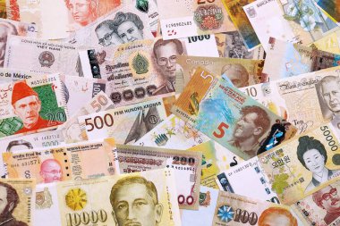 Çeşitli para birimleri para banknotları sarı ve turuncu renklerde. Farklı ülkelerden gelen birçok nakit para yığını yakın mesafede. Dünya ekonomisi ve döviz kuru kavramı