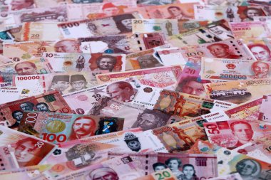 Çeşitli para birimleri para banknotları kırmızı renkli. Farklı ülkelerden gelen birçok nakit para yığını yakın mesafede. Dünya ekonomisi ve döviz kuru kavramı