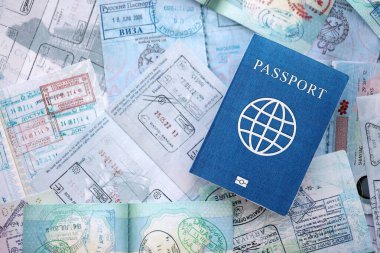 Seyahat ve sınır geçişinden sonra içi renkli pullarla dolu bir pasaport. Turizm ve sınır denetimi kavramı. Göçmenlik ve dünya çapında seyahat