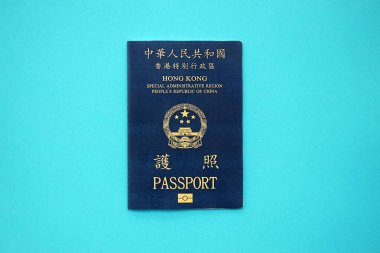 Hong Kong Özel İdari Bölgesi HKSAR pasaportu mavi masa arkasında, yakın planda. Hong Kong mavi pasaport defteri.