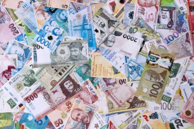 Dünyanın çeşitli para birimlerinden farklı renkte banknotlar. Masada yığınla para var. Yakın plan.