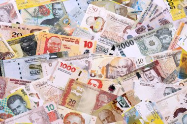 Çeşitli para birimleri para banknotları sarı ve turuncu renklerde. Farklı ülkelerden gelen birçok nakit para yığını yakın mesafede. Dünya ekonomisi ve döviz kuru kavramı